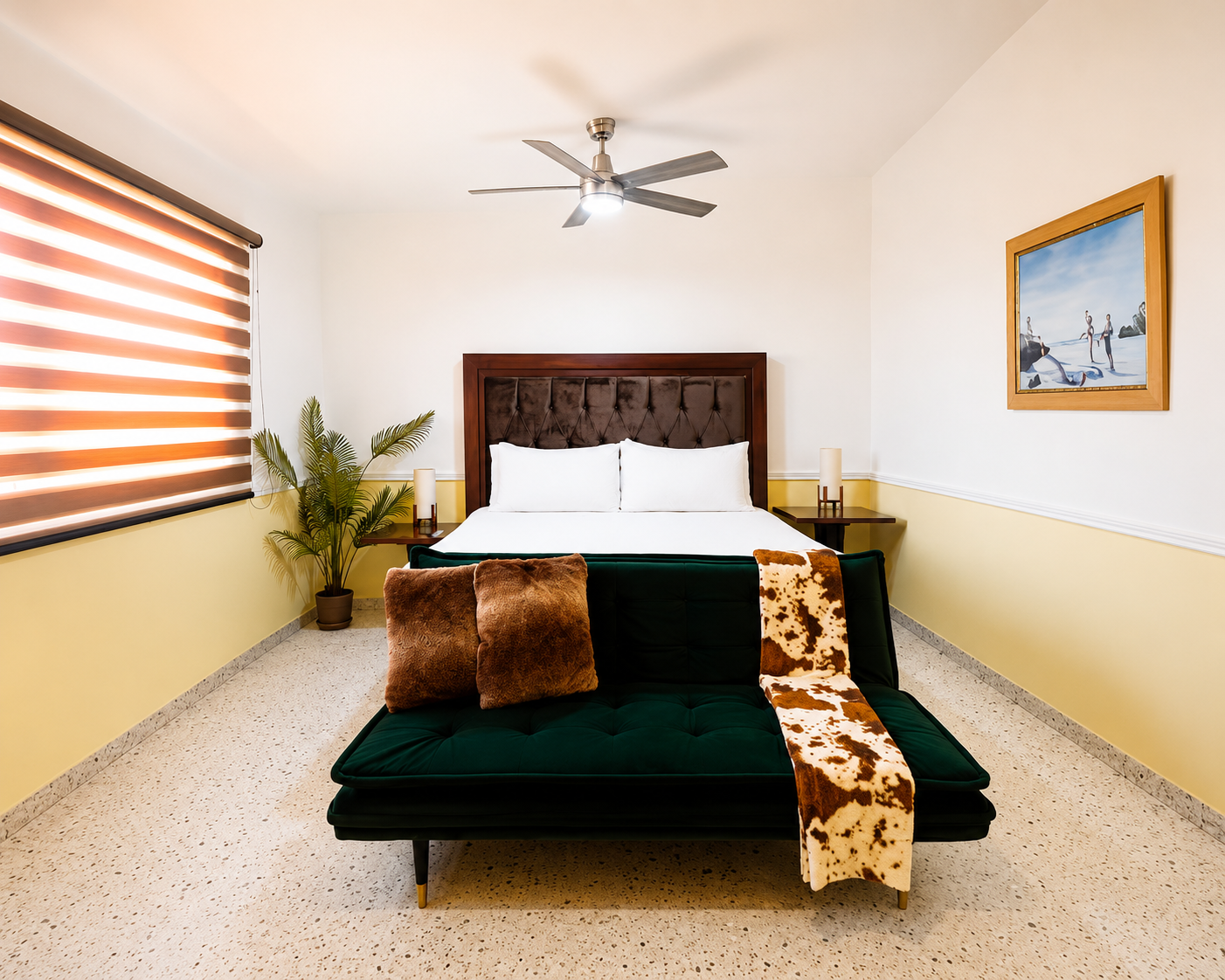Recámara con cama king size, sofá cama verde y ventilador de techo
